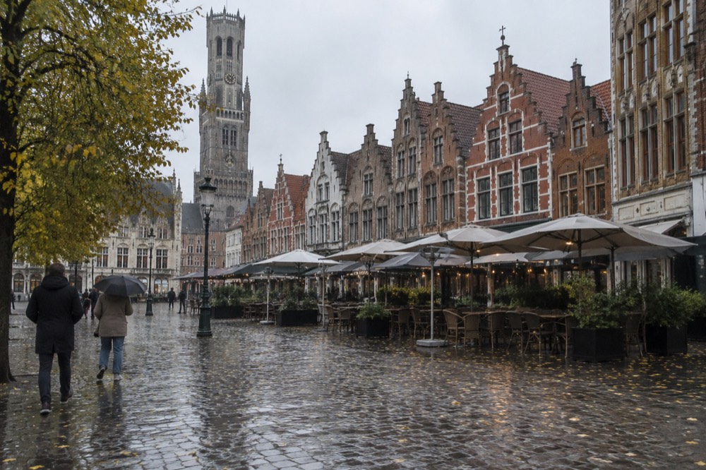 An autumn European plaza with cafe umbrellas and stone facades