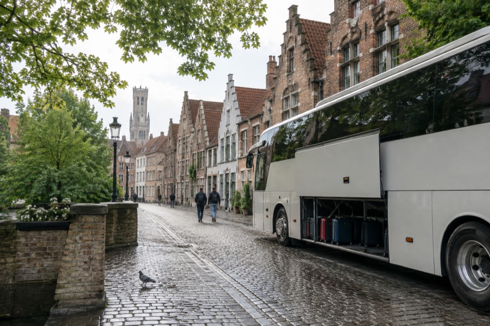 Tour coach parked on a European street beside historic buildings