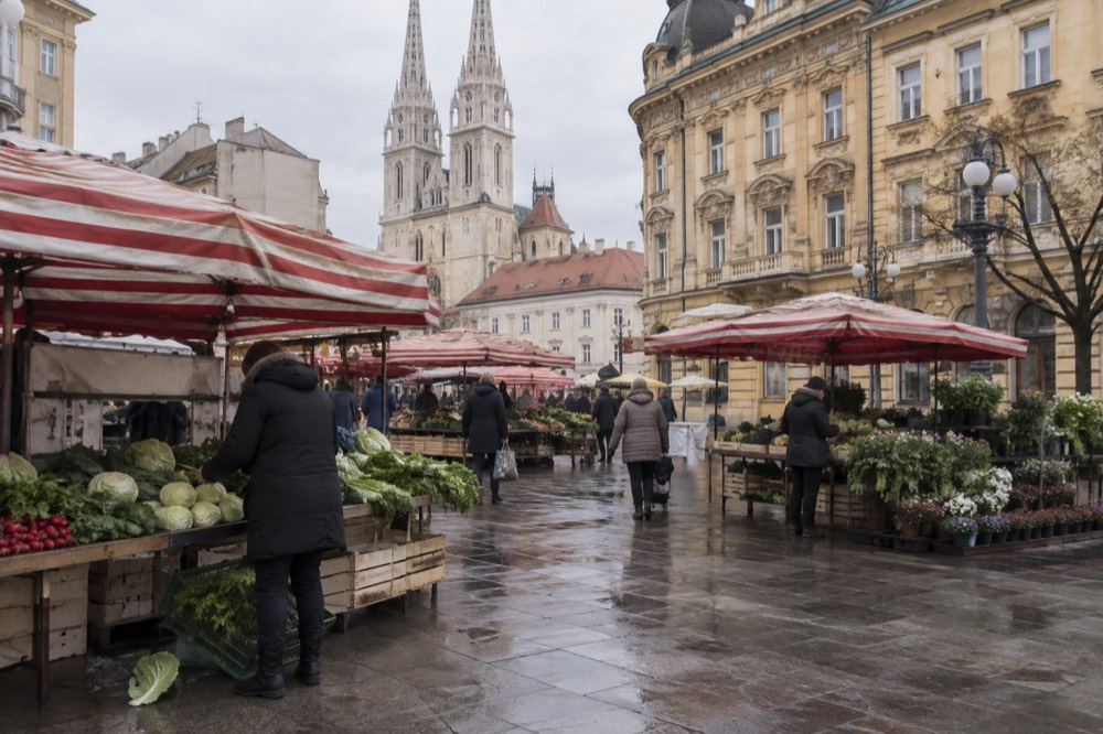 Colourful market square with low-rise pastel buildings in an Eastern European city