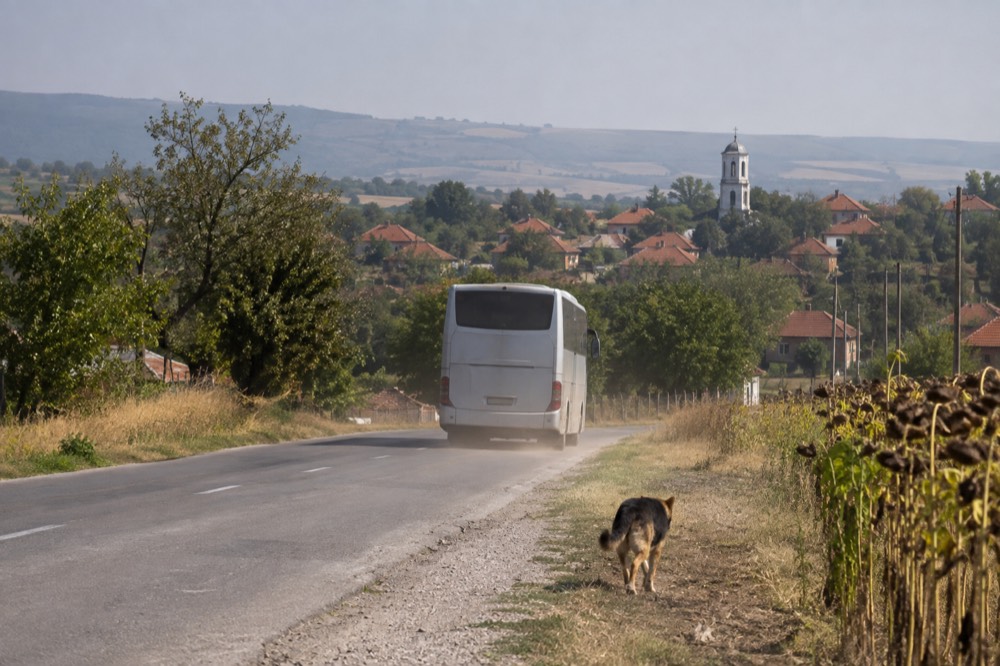 A budget tour coach on a road between European towns