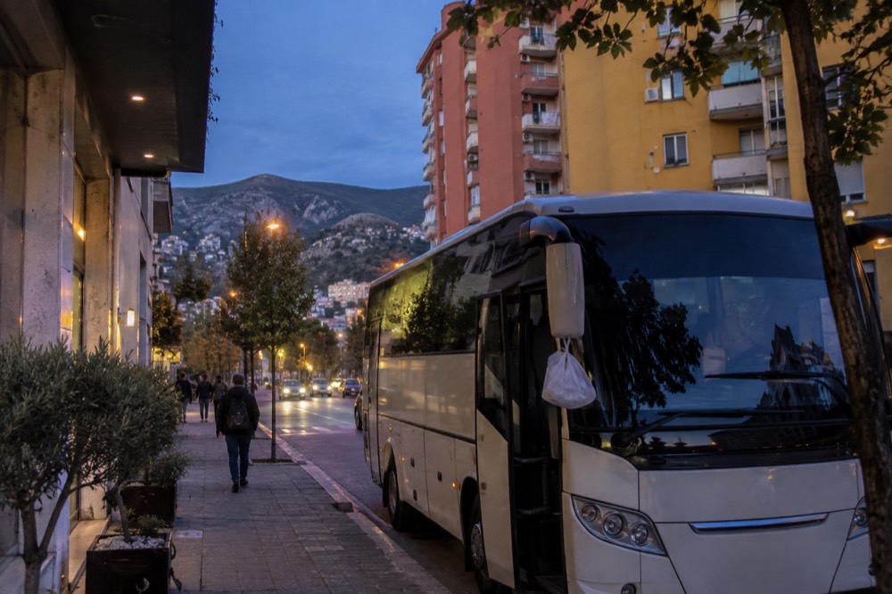 A tour coach parked outside a budget hotel at dusk