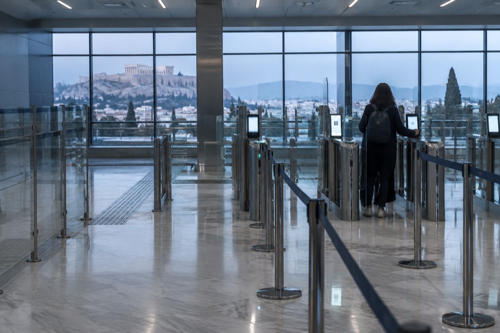 An airport passport control hall with electronic gates and queue barriers