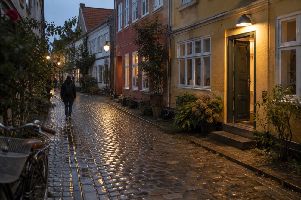 A cobbled lane curving between pastel coloured townhouses