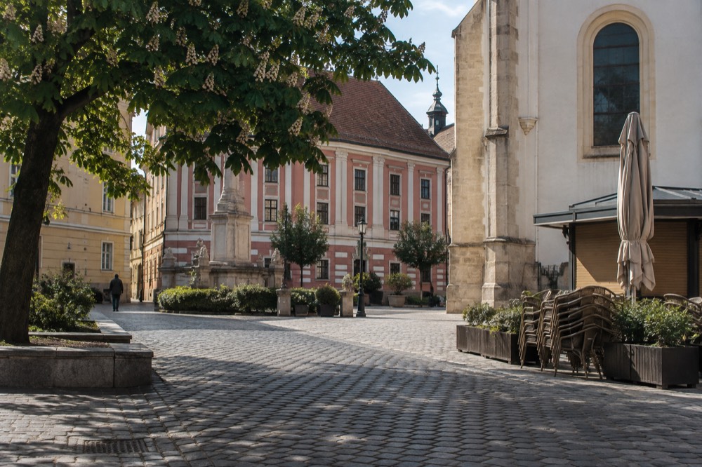 Pastel coloured buildings on a quiet cobblestone square in a Central European old town