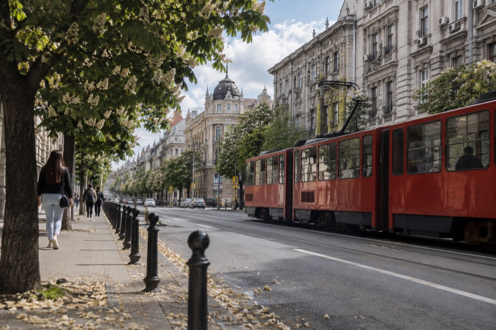A wide boulevard with grand nineteenth century buildings and tram lines in a Central European capital