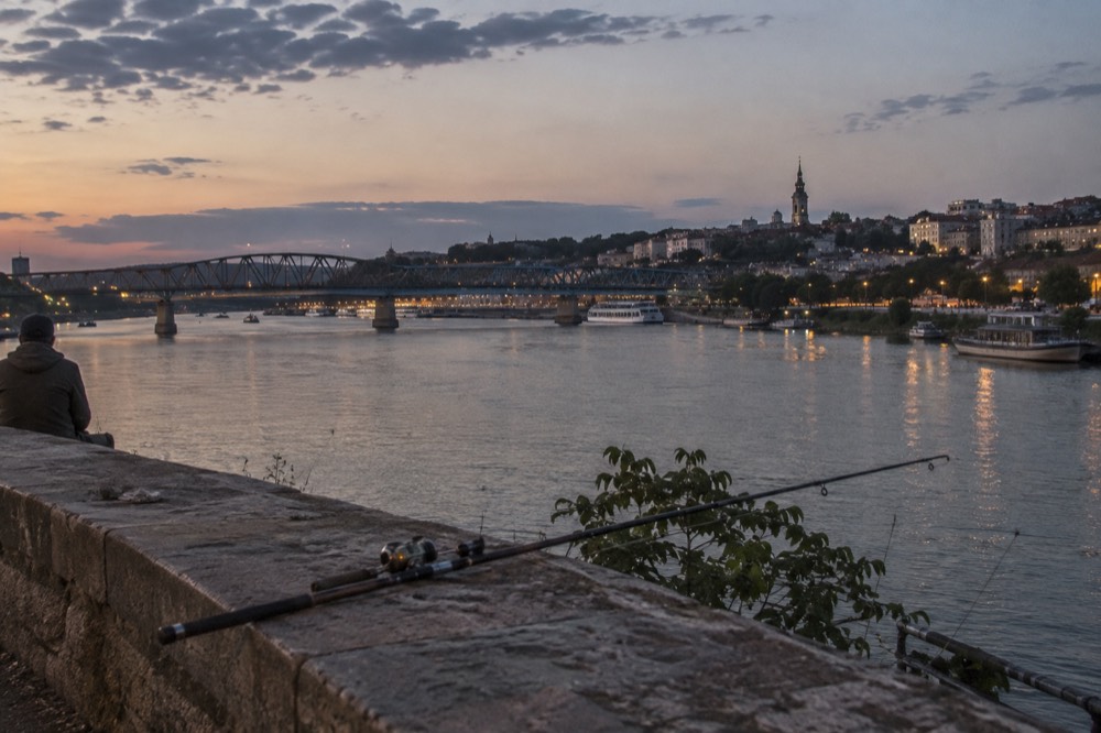 A stone bridge over a river in an old Balkan town at dusk